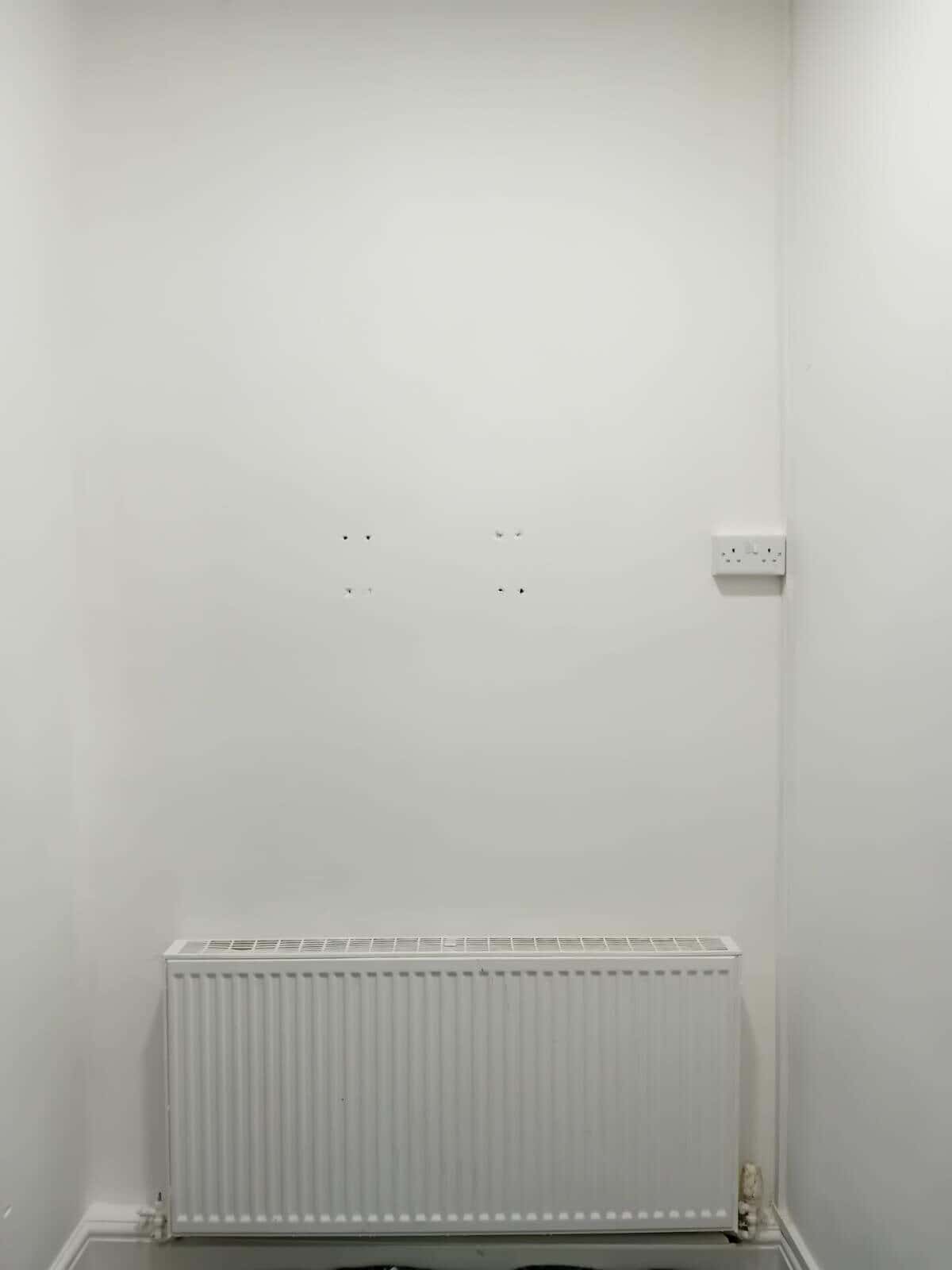 After: wall above the radiator smooth and painted white