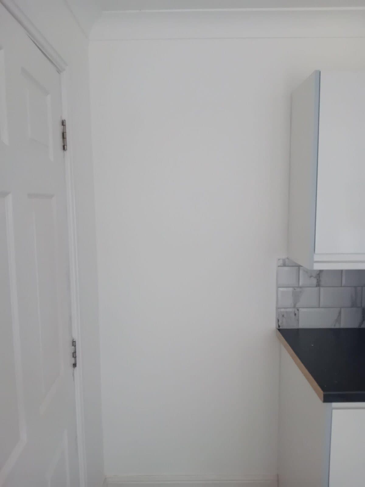 After: the plaster patch painted and blended into the white wall