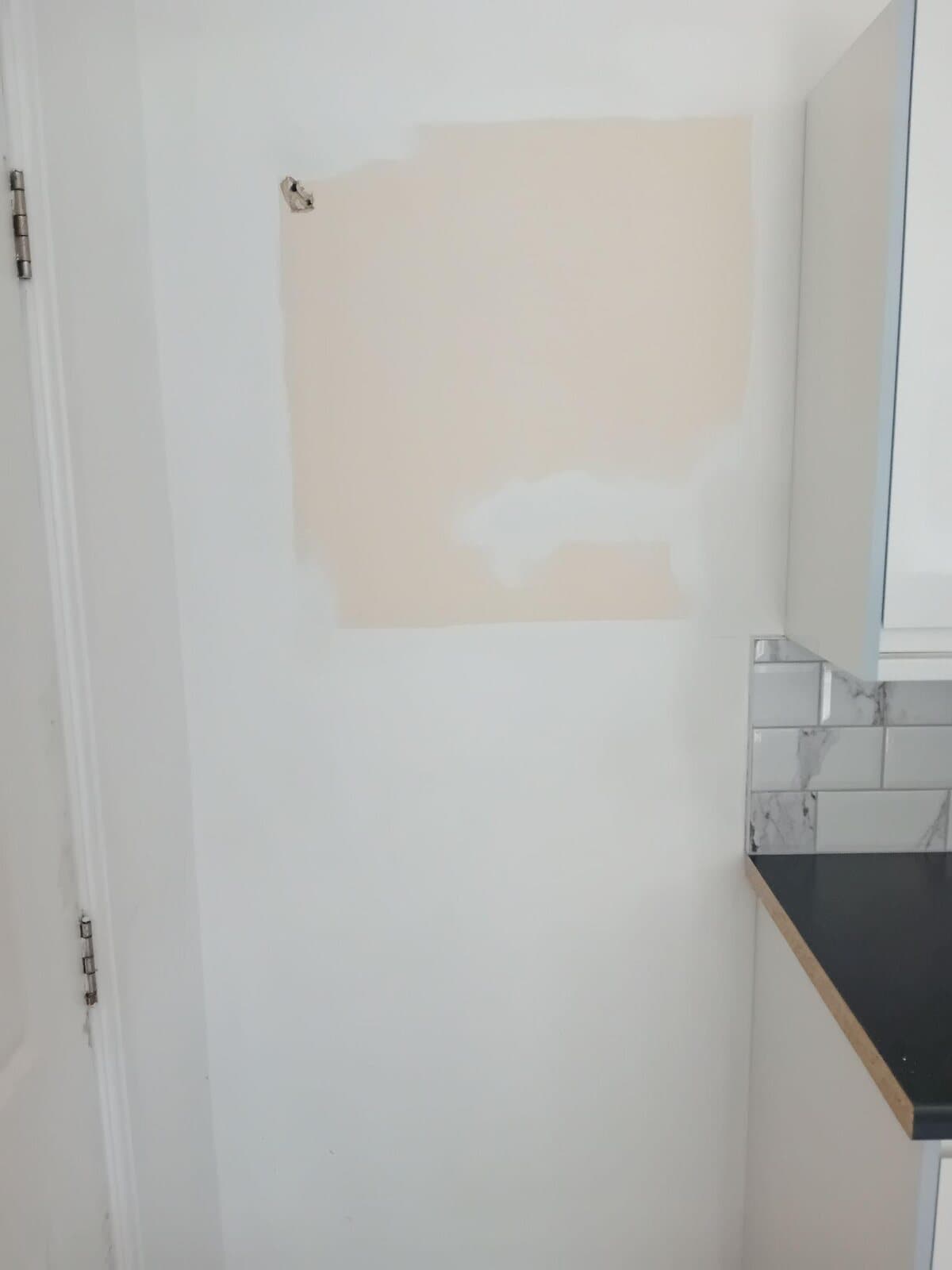 Before: kitchen wall with a bare pink plaster patch