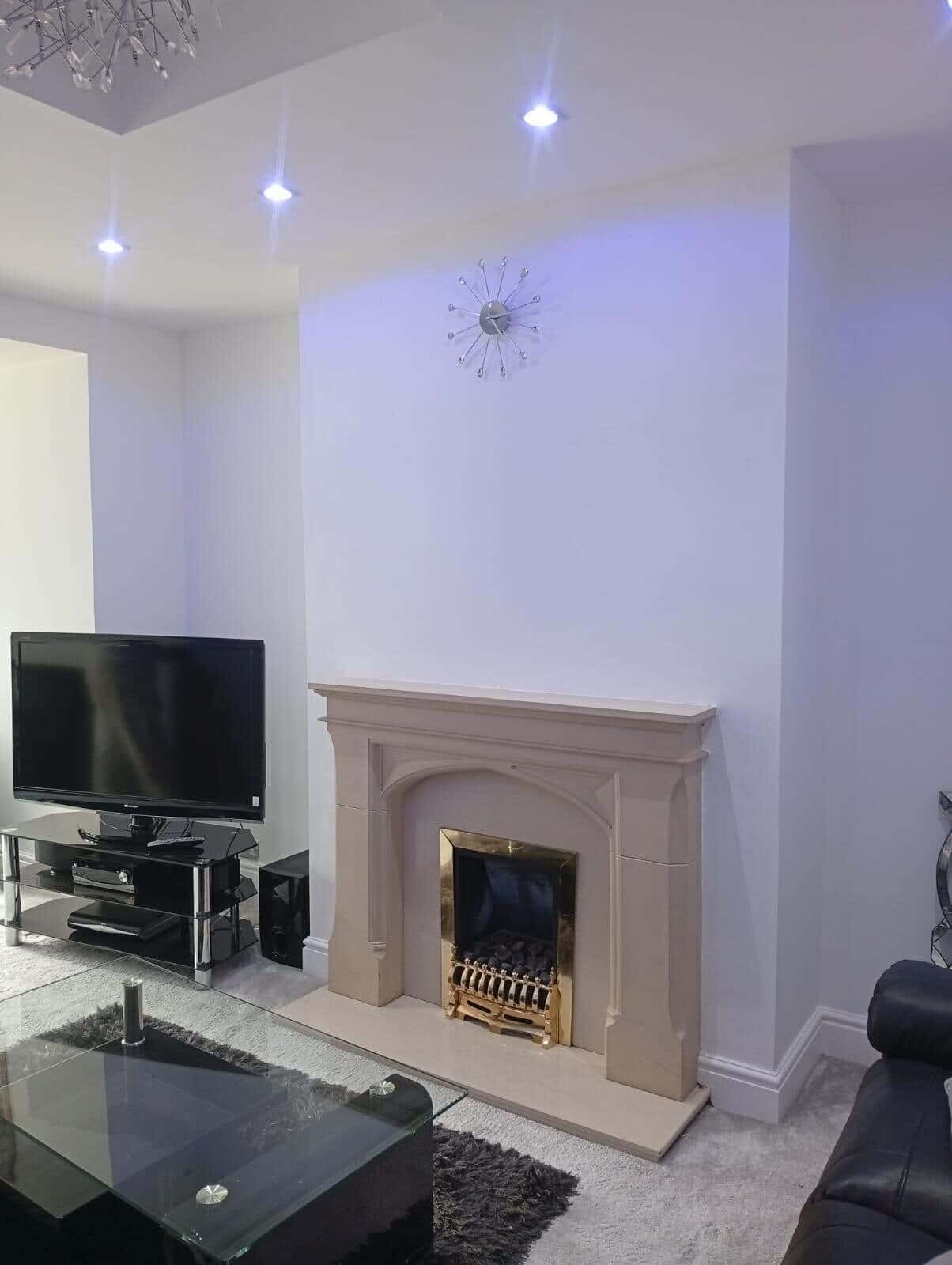After: chimney breast painted plain white above the stone fireplace