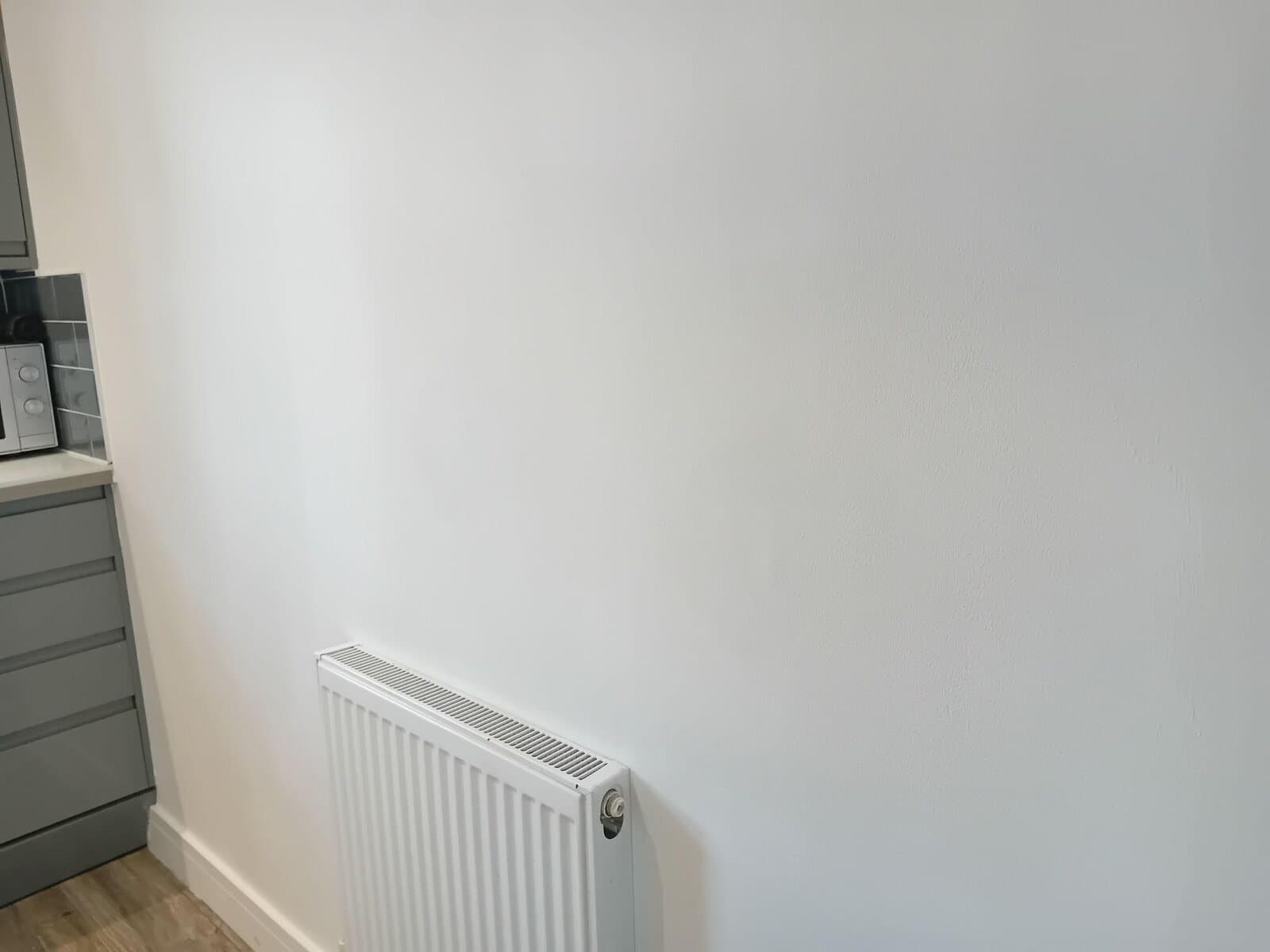 After: the same wall filled, sanded and painted plain white