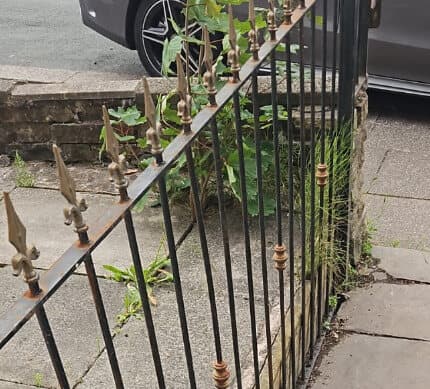 Before: worn black railings with faded gold tips