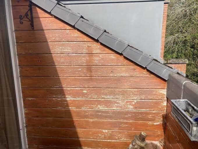 Before: weathered orange timber cladding on a balcony